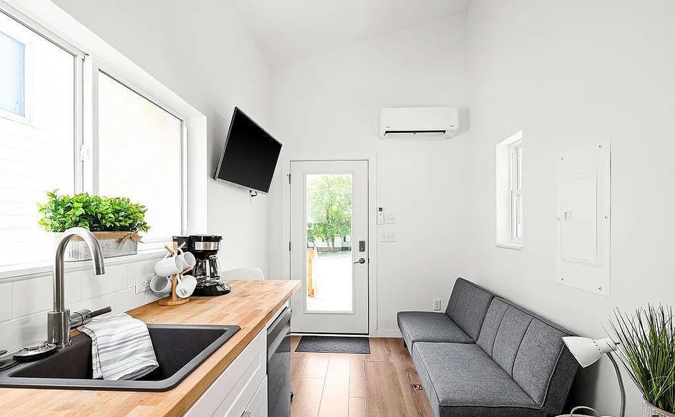 Pequena sala de estar, com sofá e TV  — Foto: Divulgação