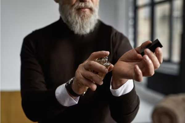 5 perfumes para o homem com mais de 50 anos receber mais elogios. Um homem grisalho passando perfume.