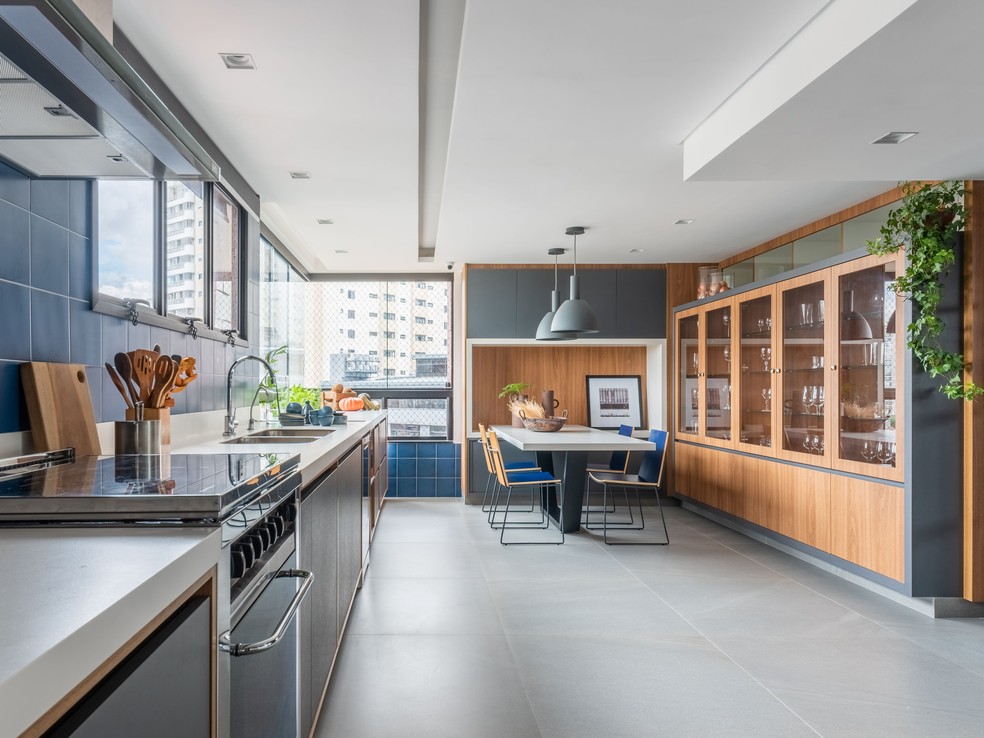 Integrada à varanda gourmet, a cozinha aumentou de tamanho, o que permitiu a criação de uma sala de almoço para a família proprietária — Foto: Guilherme Pucci