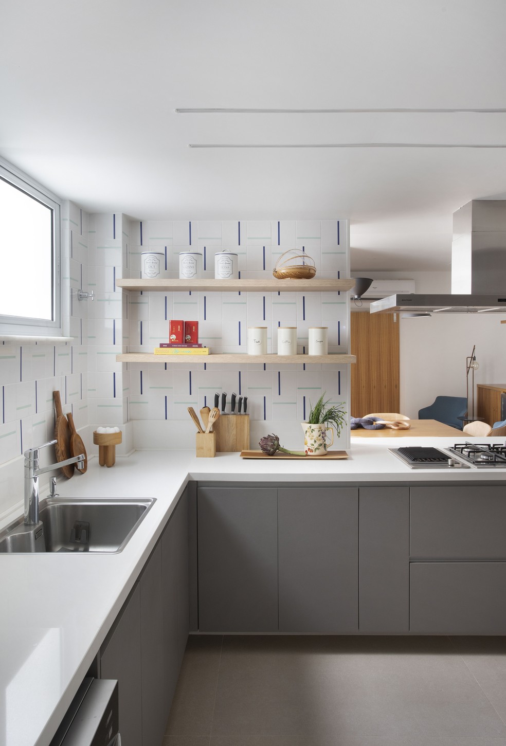 O backsplash da cozinha apresenta azulejos com detalhes geométricos e minimalistas em dois tons de azul — Foto: Juliano Colodeti/MCA Estúdio