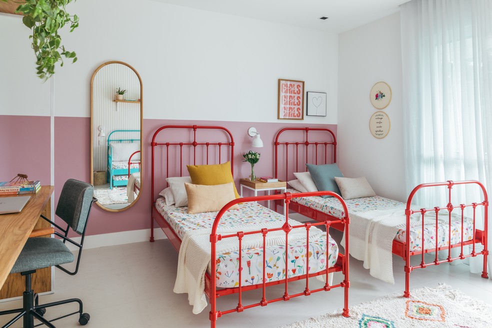 Camas vermelhas com estética vintage são destaques no quarto reformado para três irmãs — Foto: Luiza Schreier