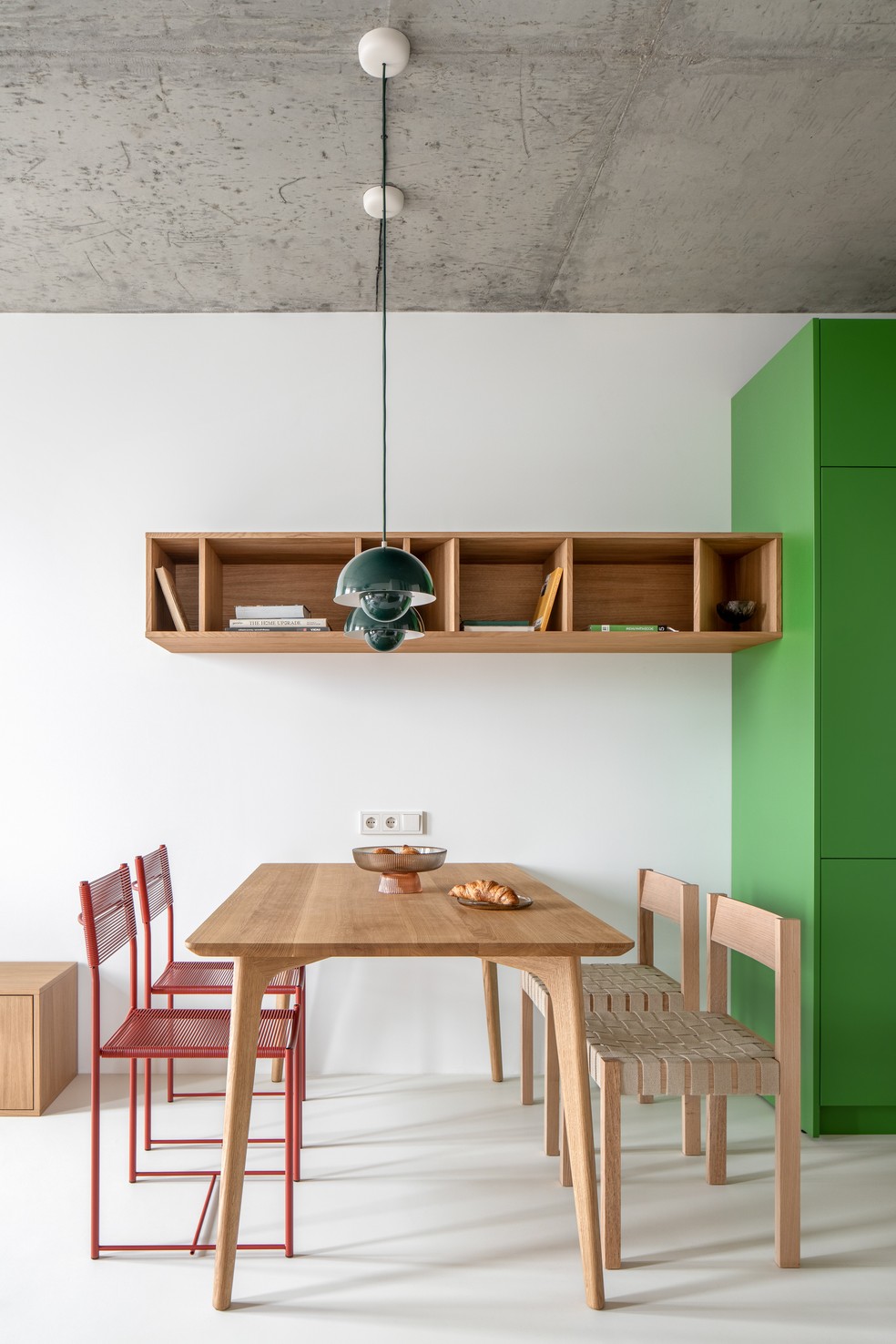 Na pequena sala de jantar, Victoria combinou dois tipos de cadeiras - repare no acabamento em madeira clara, que referencia o estilo escandinavo — Foto: Andrey Bezuglov