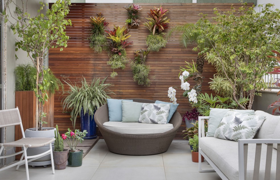O terraço ocupa 40 m² do apartamento e foi decorado com bancos e chaises, além de inúmeros vasos de plantas — Foto: Denilson Machado/MCA Estúdio 