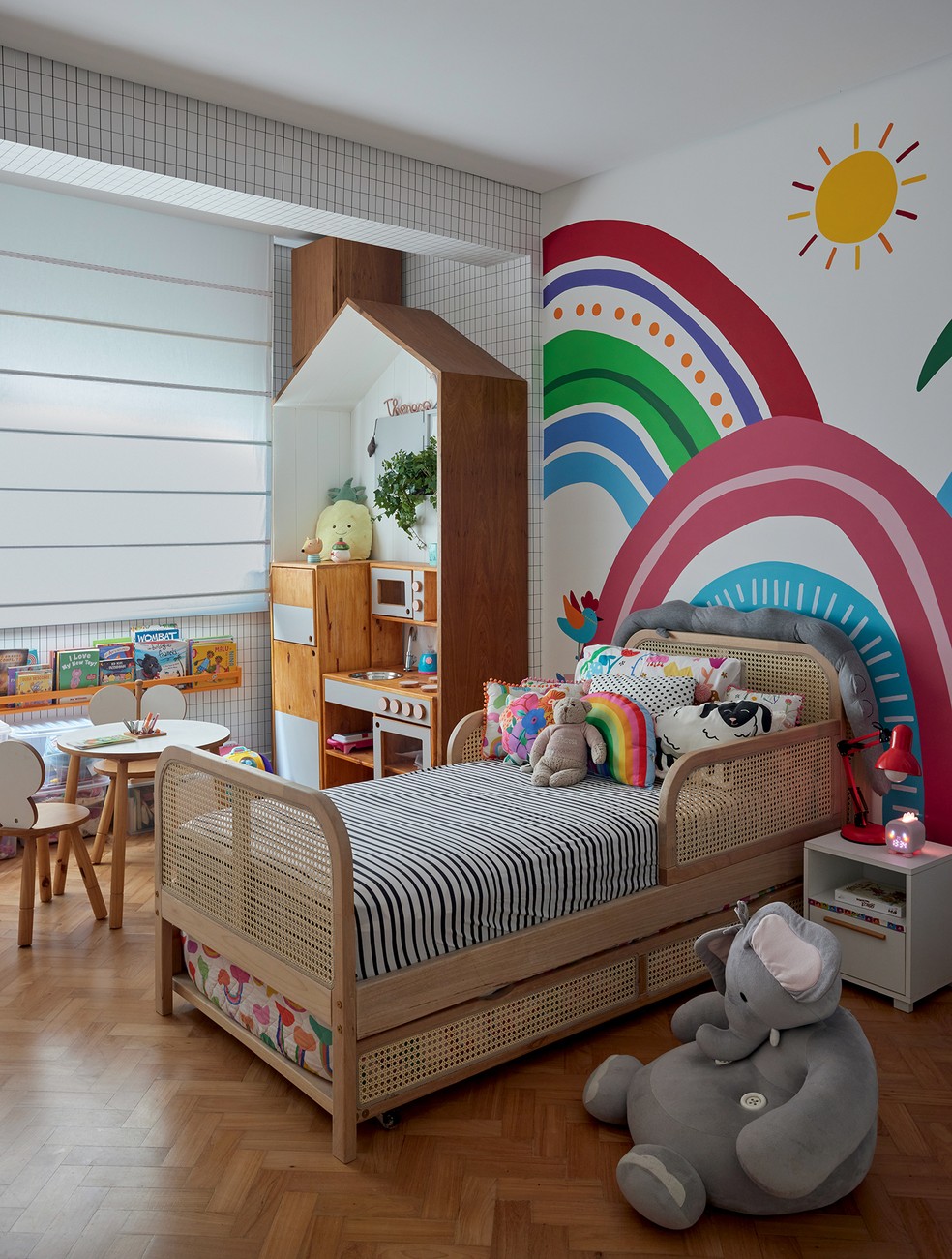 No quarto de Theresa, o tema “arco-íris”, escolhido pela menina, serviu de inspiração para o painel multicolorido, pintado à mão por Giuliana Favero — Foto: André Klotz