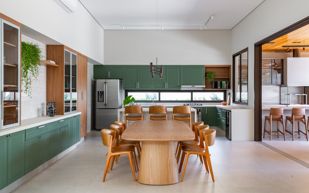 Armários na cor verde e madeira são os protagonistas no projeto de reforma desta cozinha no interior de São Paulo — Foto: Favaro Jr.