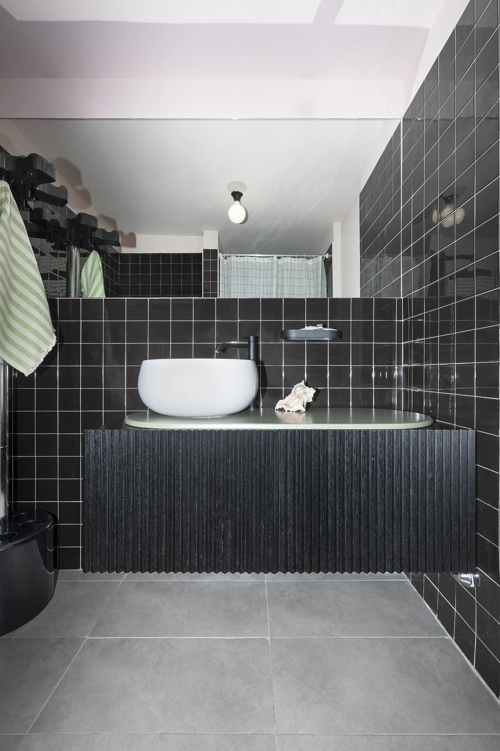 A estética do banheiro, com tons de preto e verde, é diferente do restante do loft — Foto: Beppe Brancato