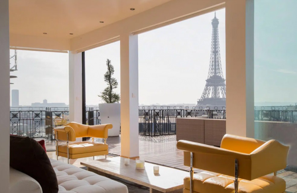 Sala de estar conta com vista privilegiada para a Torre Eiffel — Foto: Divulgação