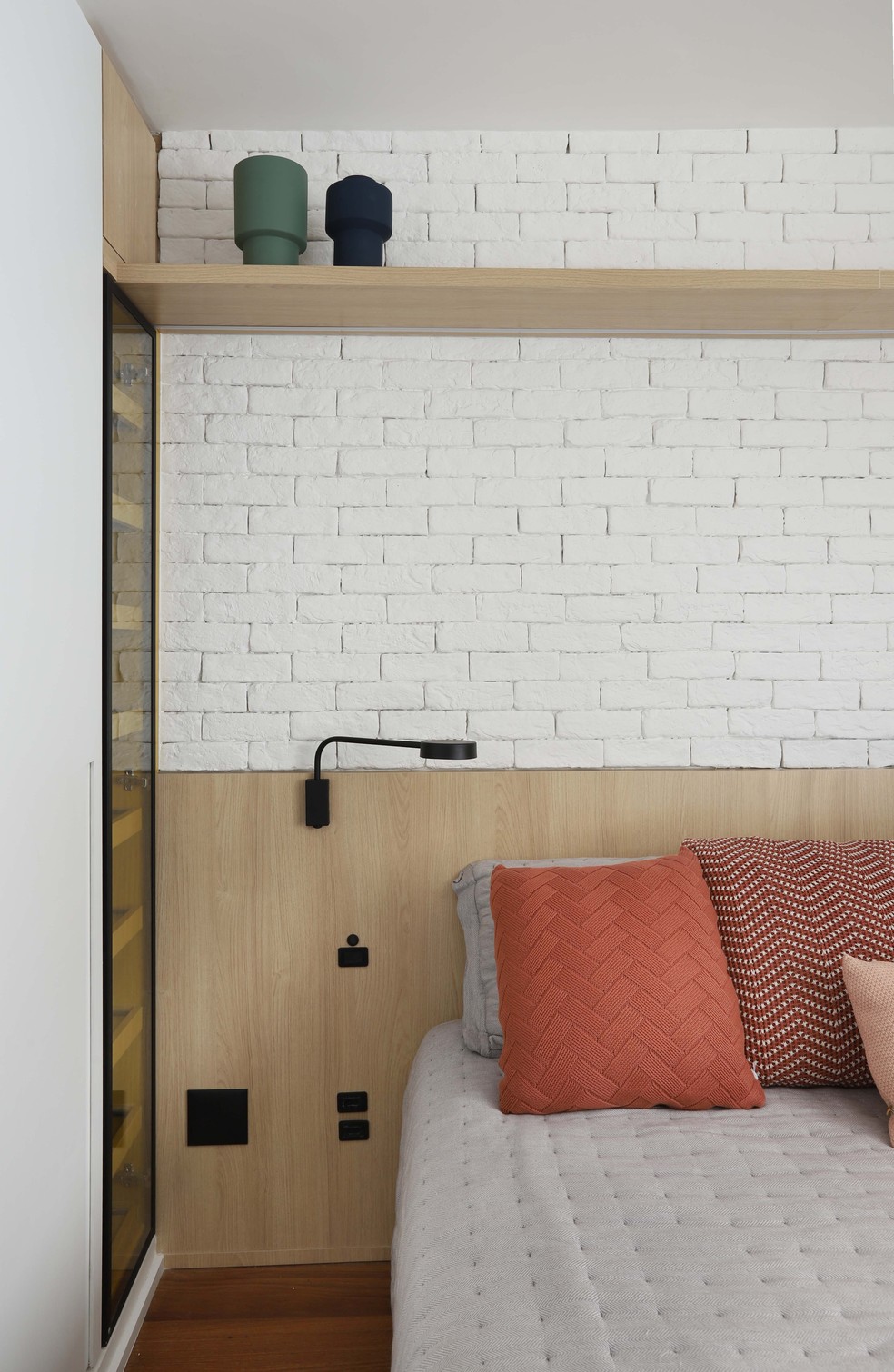 A parede de tijolinhos também aparece no quarto principal emoldurando a cabeceira da cama — Foto: Mariana Orsi
