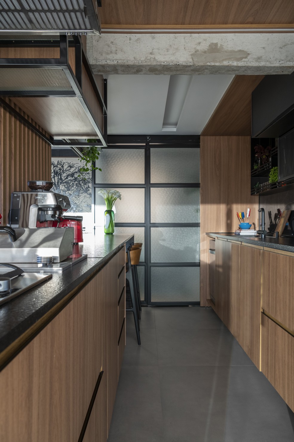 Com armários no perímetro do corredor, a cozinha é bastante prática e conta com revestimentos de manutenção baixa  — Foto: Cris Farhat
