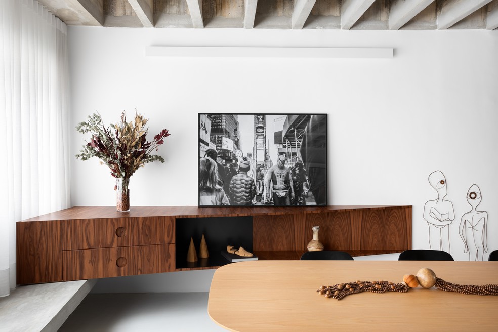 Móvel da tv em madeira natural de pau-ferro com prateleiras ‘voadoras’ em ferro preto — Foto: Alexandre Disaro
