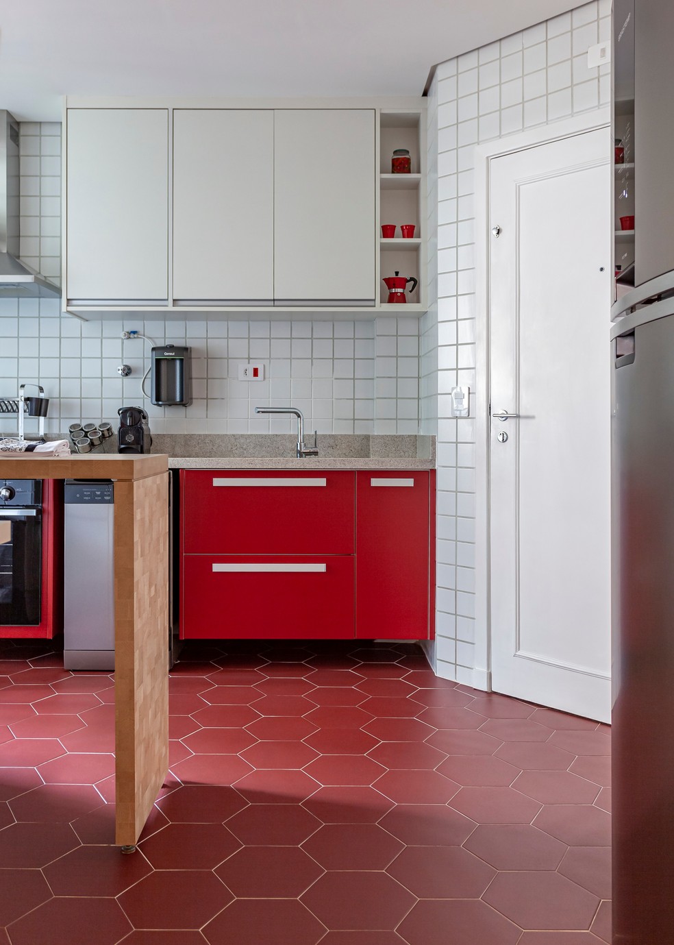 Cozinha projetada pela arquiteta Christiane Schiavoni mescla a intensidade do vermelho com a neutralidade do branco que reveste as paredes e a marcenaria — Foto: Carlos Piratininga