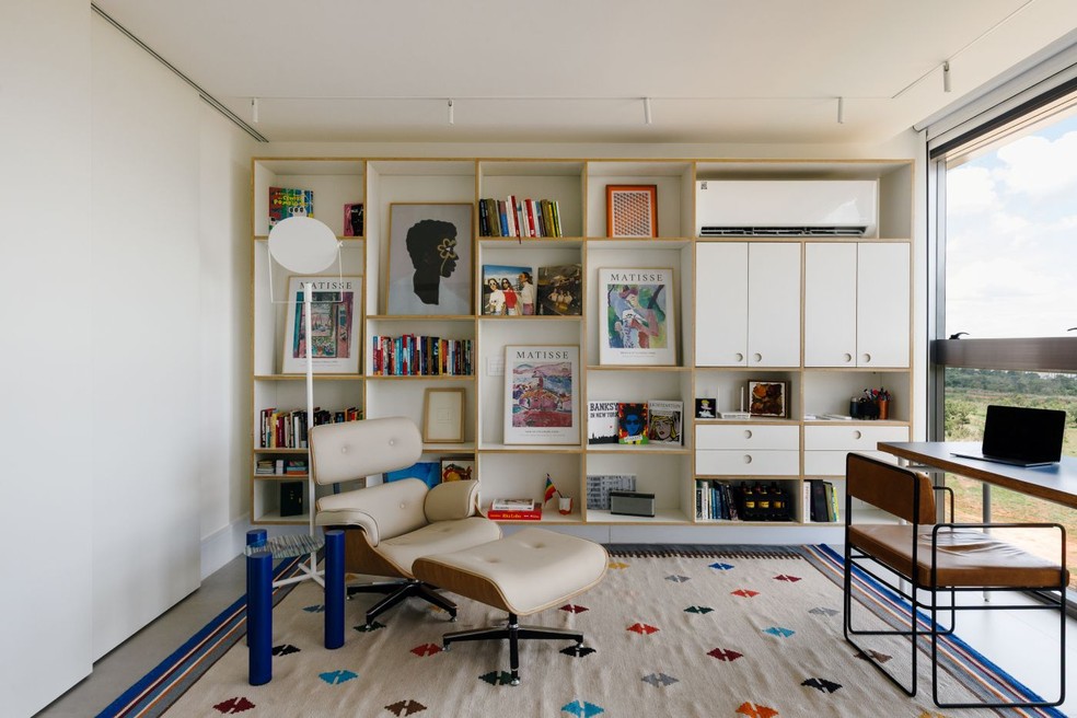 Projetado pelo Tribeira Arquitetura, este cantinho de leitura ganha personalidade com a estante branca, que também oferece espaço de armazenamento — Foto: Divulgação