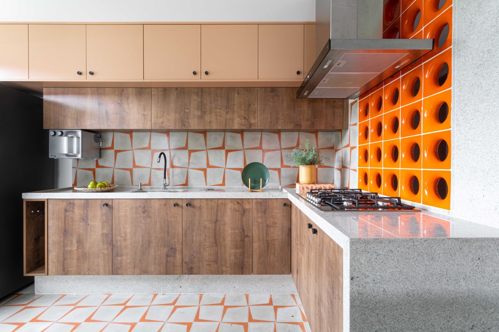 Com armários em marcenaria, cozinha ganhou tom alegre por meio do uso do laranja no piso e na divisória — Foto: Re Freitas