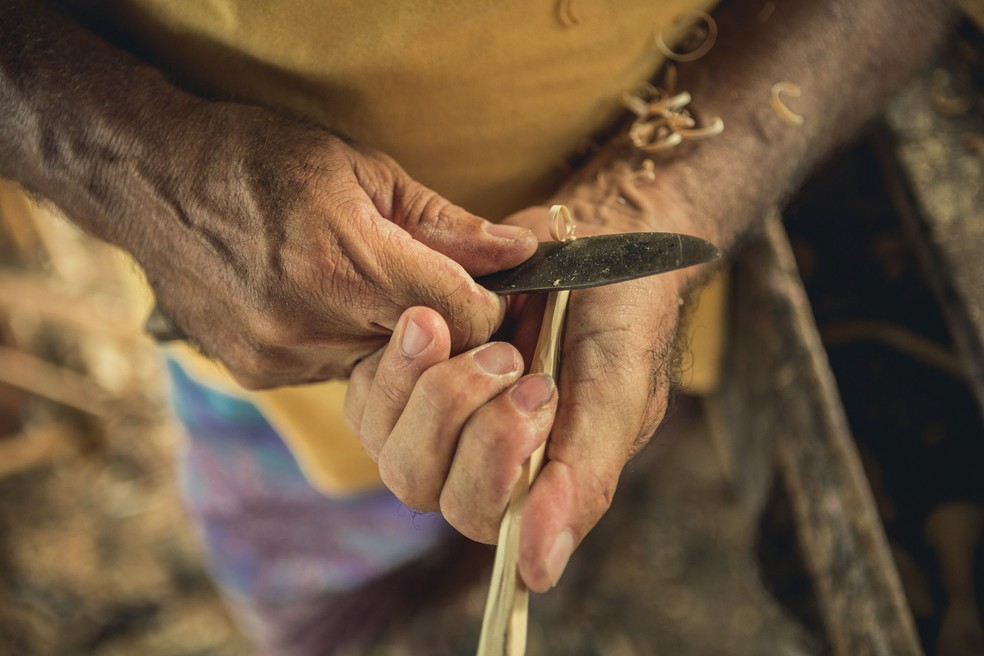 As mãos de Valmir Lessa, genro de seu Fernando e escultor, como ele, de móveis e objetos de madeira recolhida no mangue e na caatinga — Foto: Gui Gomes