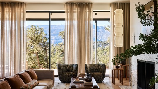 Casa exibe interiores aconchegantes e vista para a floresta, no Colorado