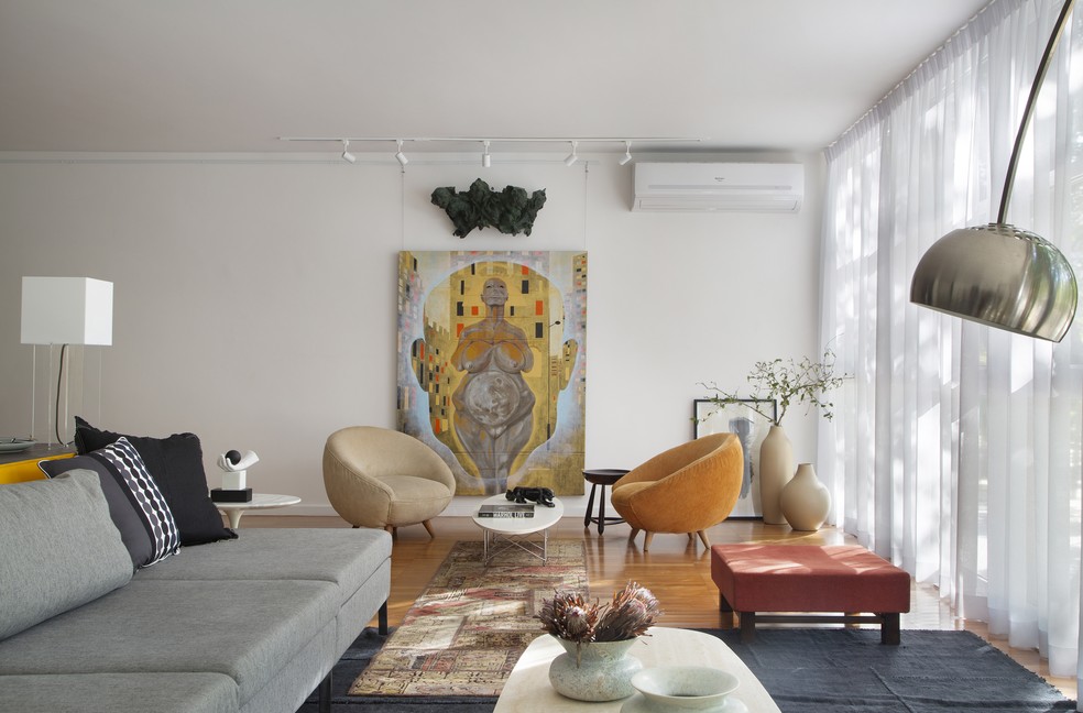 Ao fundo, quadro “Vênus primitiva”, criado por Carlos Dangeli, um dos donos do apartamento, ganha destaque no cômodo — Foto: Denilson Machado/MCA Estúdio