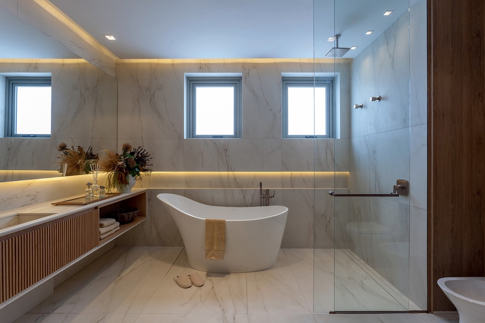 O banheiro foi equipado com banheira Amalfi, da Doka, bancada com cuba esculpida em Dekton Rem e piso e paredes de Silestone Rem, tudo da Cosentino — Foto: Tuca Reinés