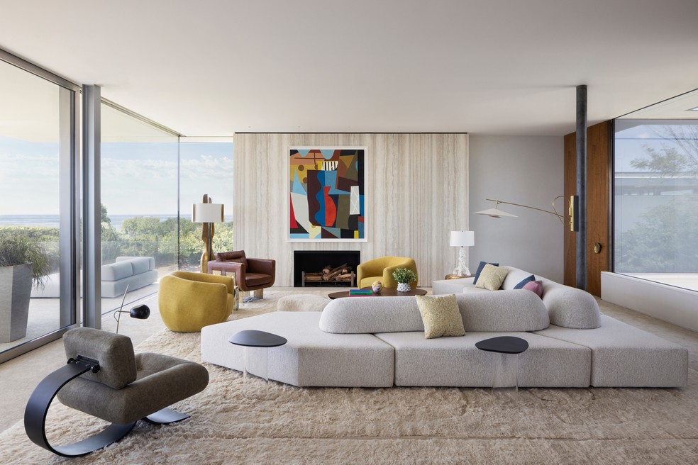 À esq., poltrona Alta, de Oscar Niemeyer, compõe mobiliário da sala de estar em Hamptons, nos Estados Unidos, com toques de cores com tela, do artista Rodney Graham — Foto: Eric Petschek