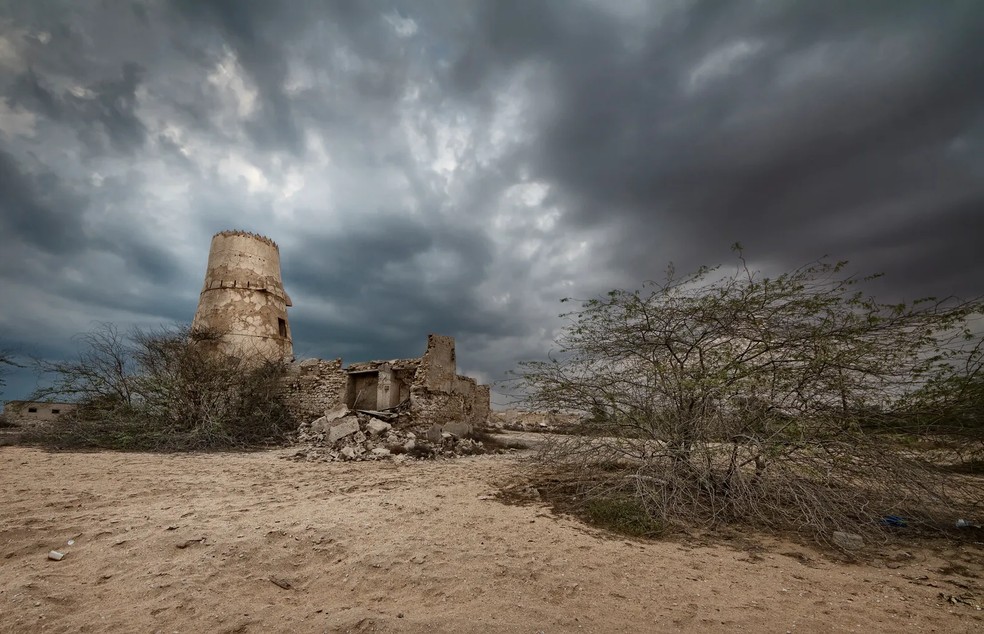 Uma tempestade passa por Al Jazira Al Hamra. O clima árido costumava abrigar uma vila de empreendimento aquático — Foto: Getty Images/Michael R. Cruz