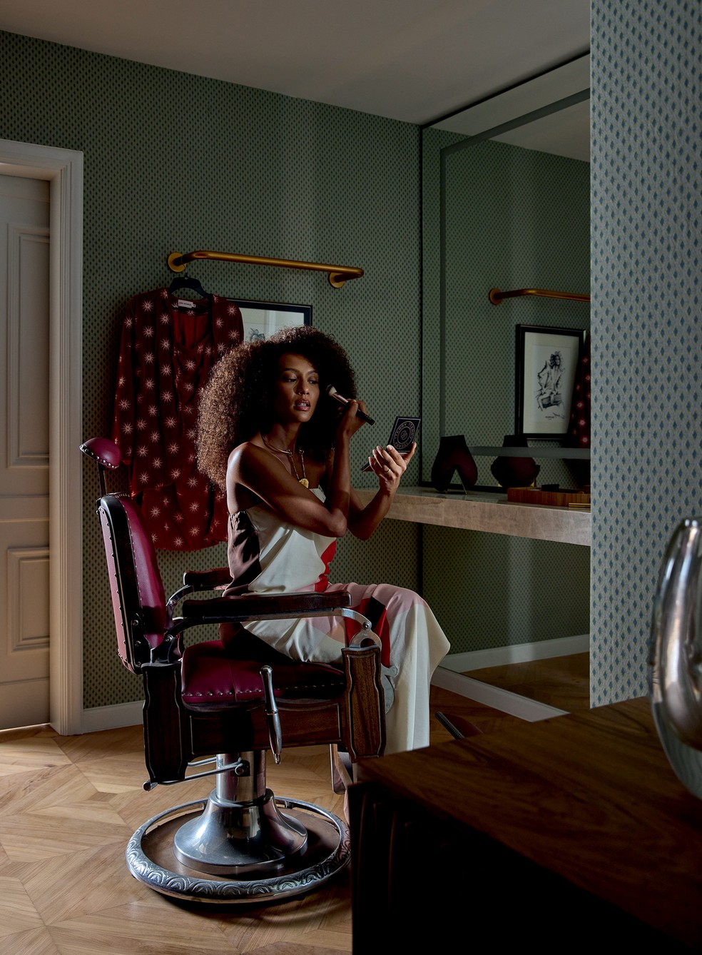 Tas, de vestido Laura Cangussu e colar Vix, se maquia na poltrona de camarim antiga, de seu acervo  a parede leva tecido jacquard Maya Denim, da Espao Multi  Foto: Andr Klotz | Estilo: Lucas Freitas