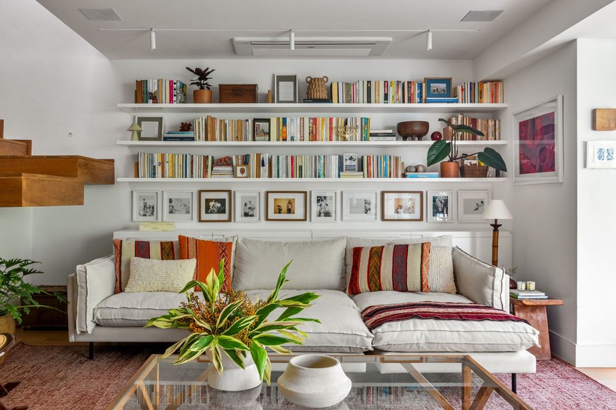 Desenhada pelo Sadala Gomide Arquitetura, esta sala de estar ganha tom aconchegante por meio da prateleira com livros