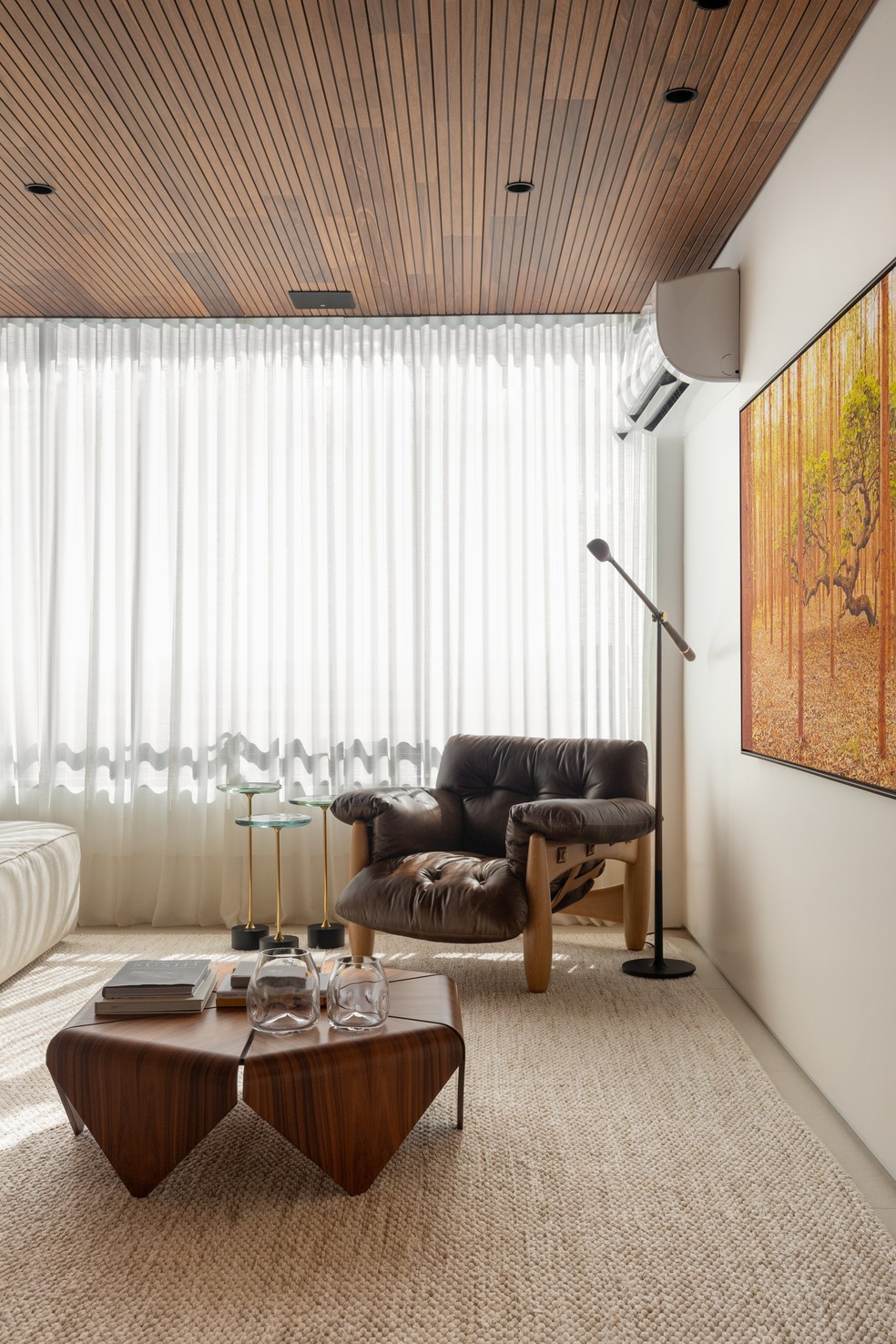 Este cantinho do living foi decorado com mesa de centro Pétalas, de Jorge Zalszupin, poltrona Mole, de Sergio Rodrigues, e mesas laterais Jardim, de Jader Almeida - tudo sobre tapete da Carminati — Foto: Júlia Tótoli