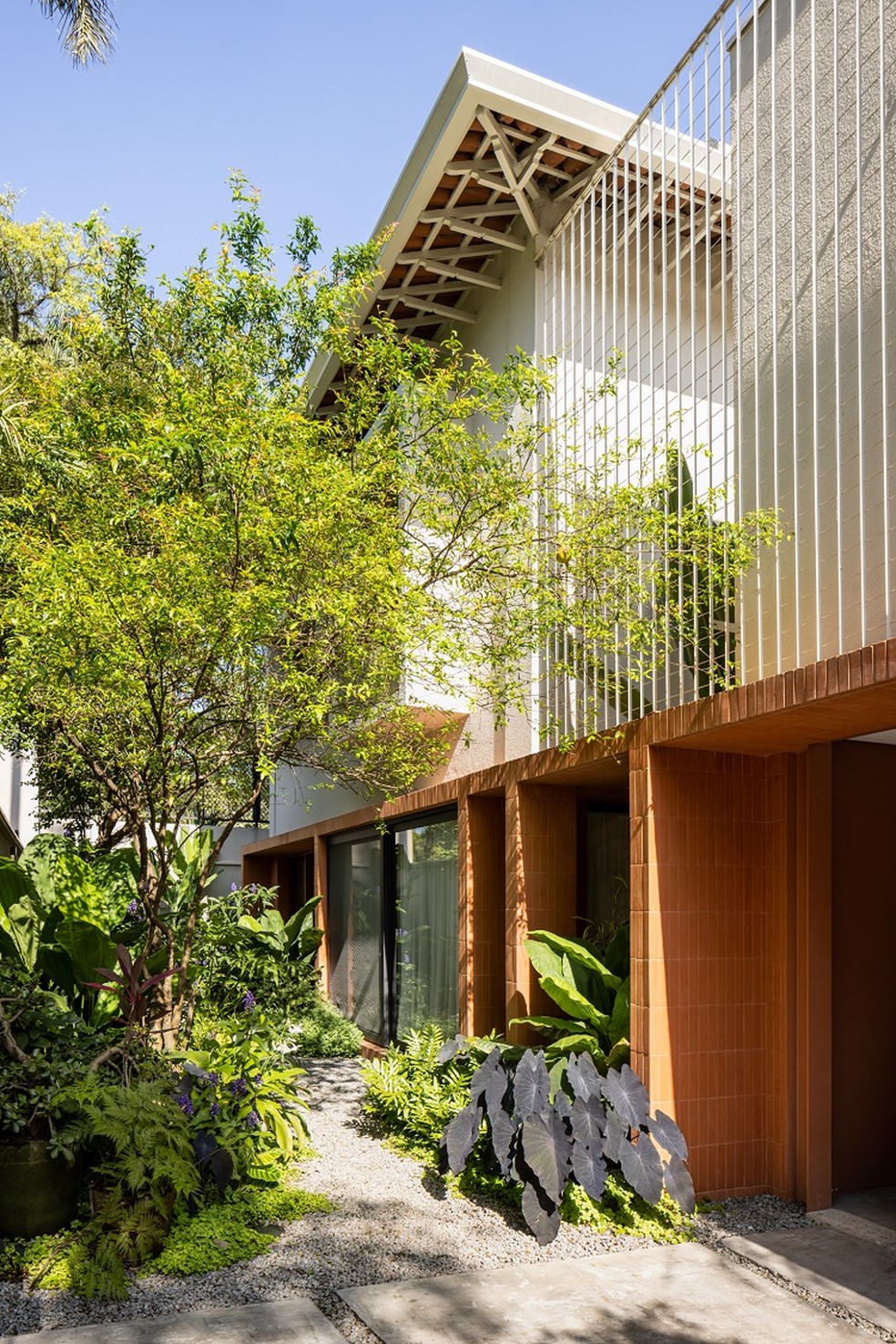 Fachada de casa térrea e contemporânea com pórtico revestida com