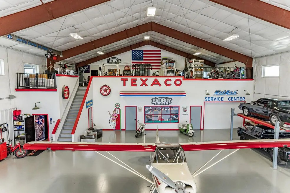 O hangar, que ainda pode abrigar uma aeronave, abriga uma academia, sala de recreação e outra cozinha — Foto: Divulgação/Coldwell Banker