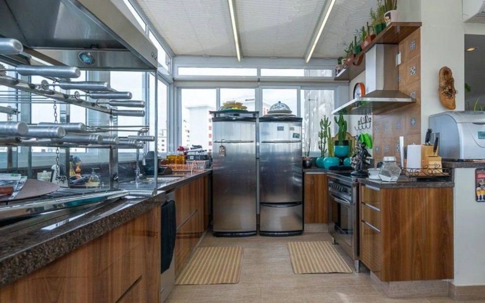 A cozinha do apartamento tem armários de madeira  — Foto: RE/MAX URBAN