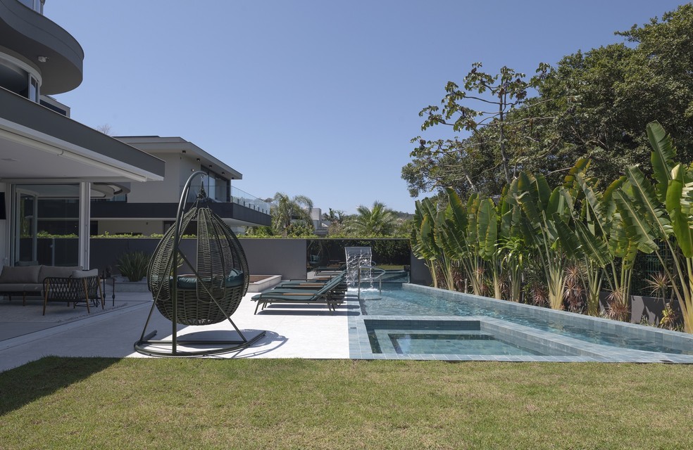 Na área da piscina, o arquiteto setorizou ambientes de estar, receber e relaxar — Foto: Lio Simas