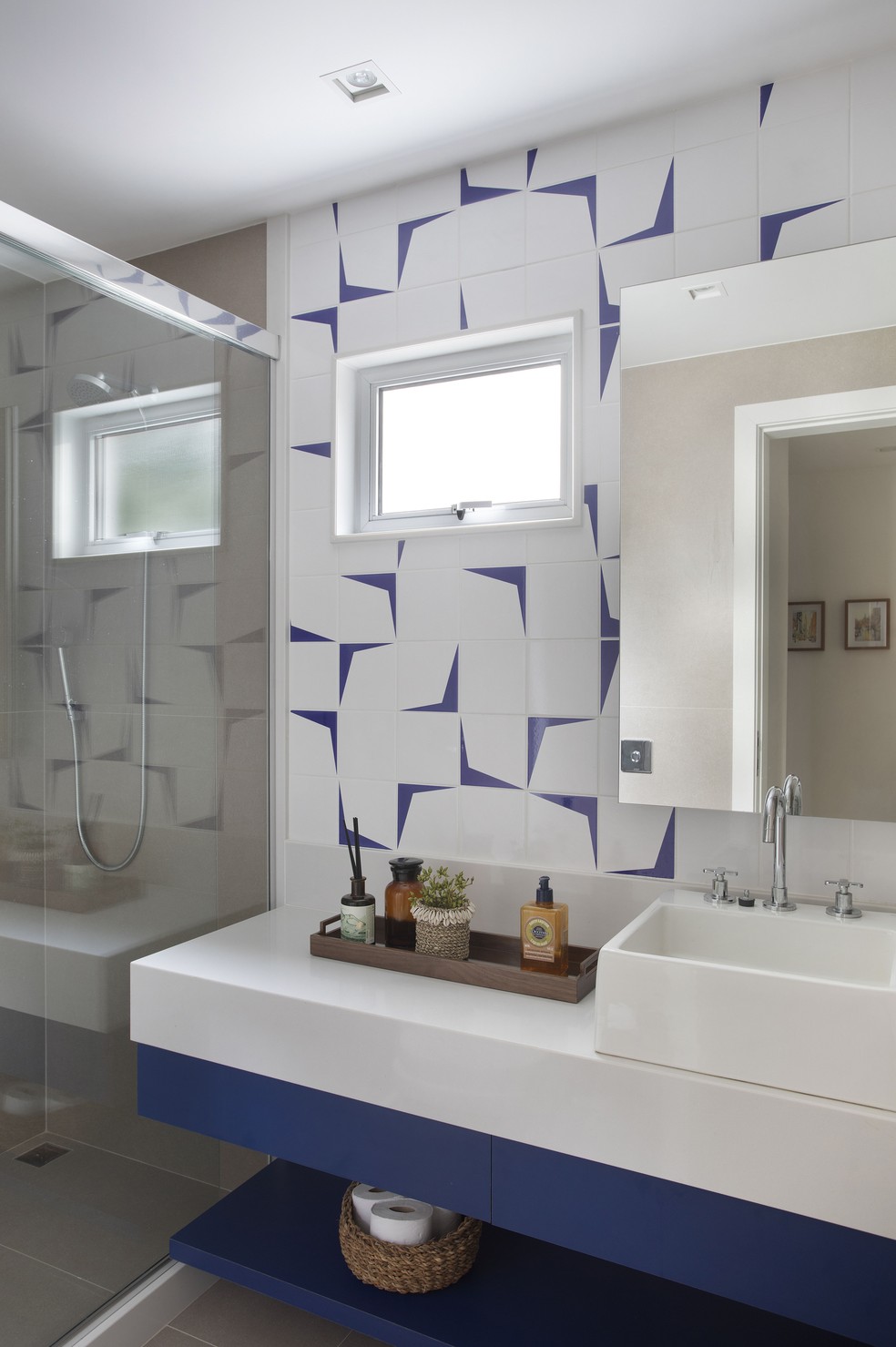 Neste outro banheiro do apartamento, os azulejos e a marcenaria azuis reverberam a paleta de cores da cozinha — Foto: Juliano Colodeti/MCA Estúdio