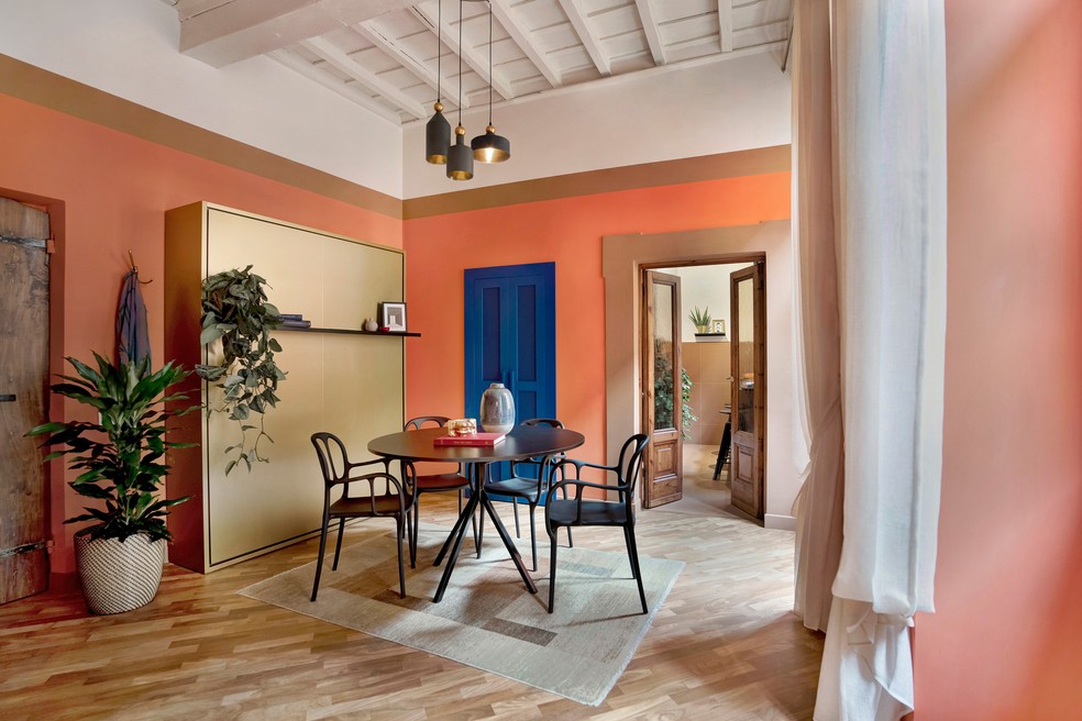 Sala de jantar com tem o uso do mobiliário de madeira como protagonista — Foto: Michele Bonechi