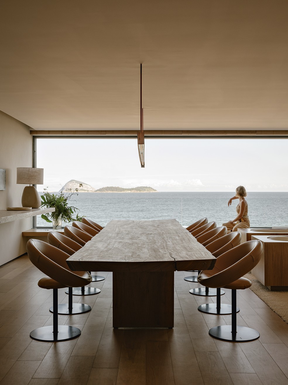 A vista do mar invade a sala de jantar, equipada com mesa de madeira maciça, da Tora Brasil, e cadeiras Anel, de Ricardo Fasanello, no Arquivo Contemporâneo  — Foto: Fran Parente