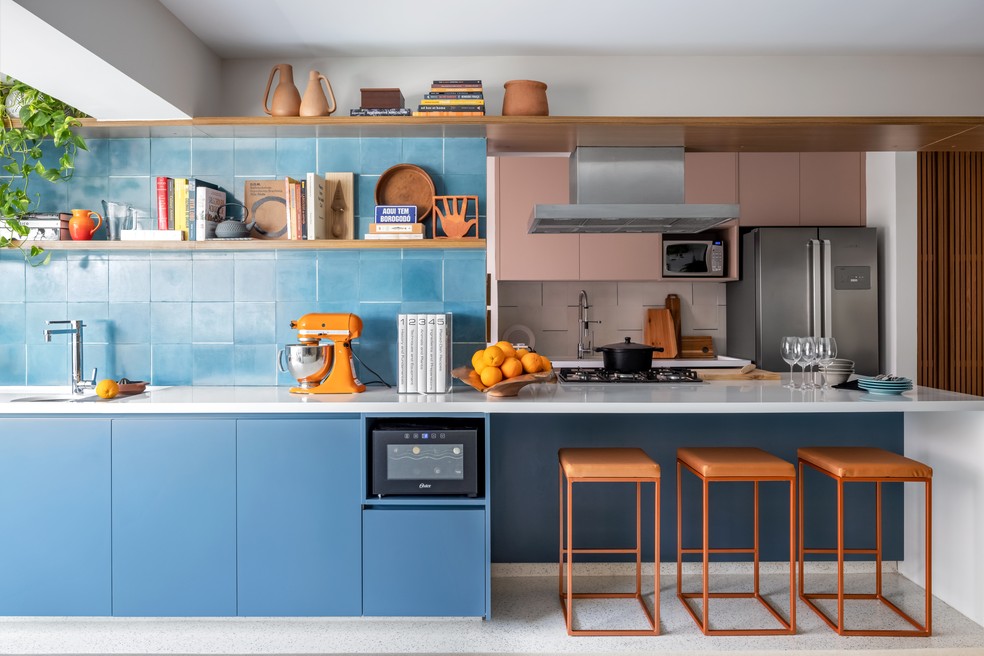 Cozinha foi dividida em duas partes: uma interna, com armários em tom de rosa, e uma parte externa com bancada e ladrilho azul — Foto: Ana Mello