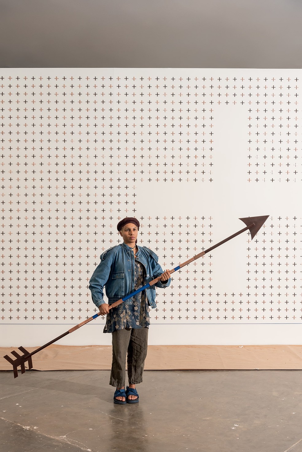 A artista visual Luana Vitra segura uma das flechas de ferro e acabamento de cobre (com função de patuá) integrante da instalação que retrata histórias da mineração e da escravidão em Minas Gerais — Foto: Wesley Diego Emes