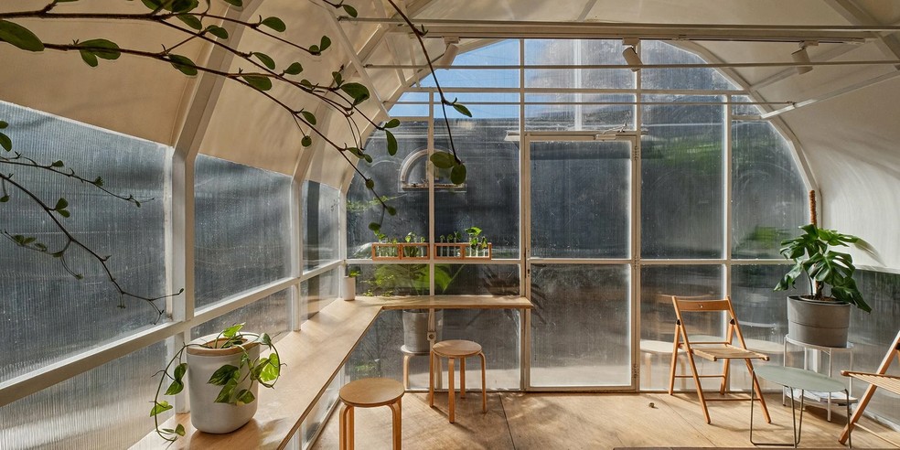 A cafeteria possui um design minimalista e muitas plantas  — Foto: Divulgação/INS Studio