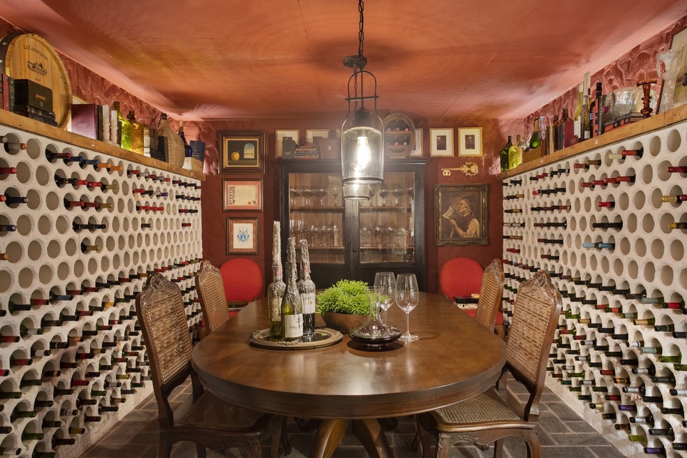 Na adega, se destaca a coleção de vinhos do Marcelo, todos separados por pais de origem — Foto: Denilson Machado