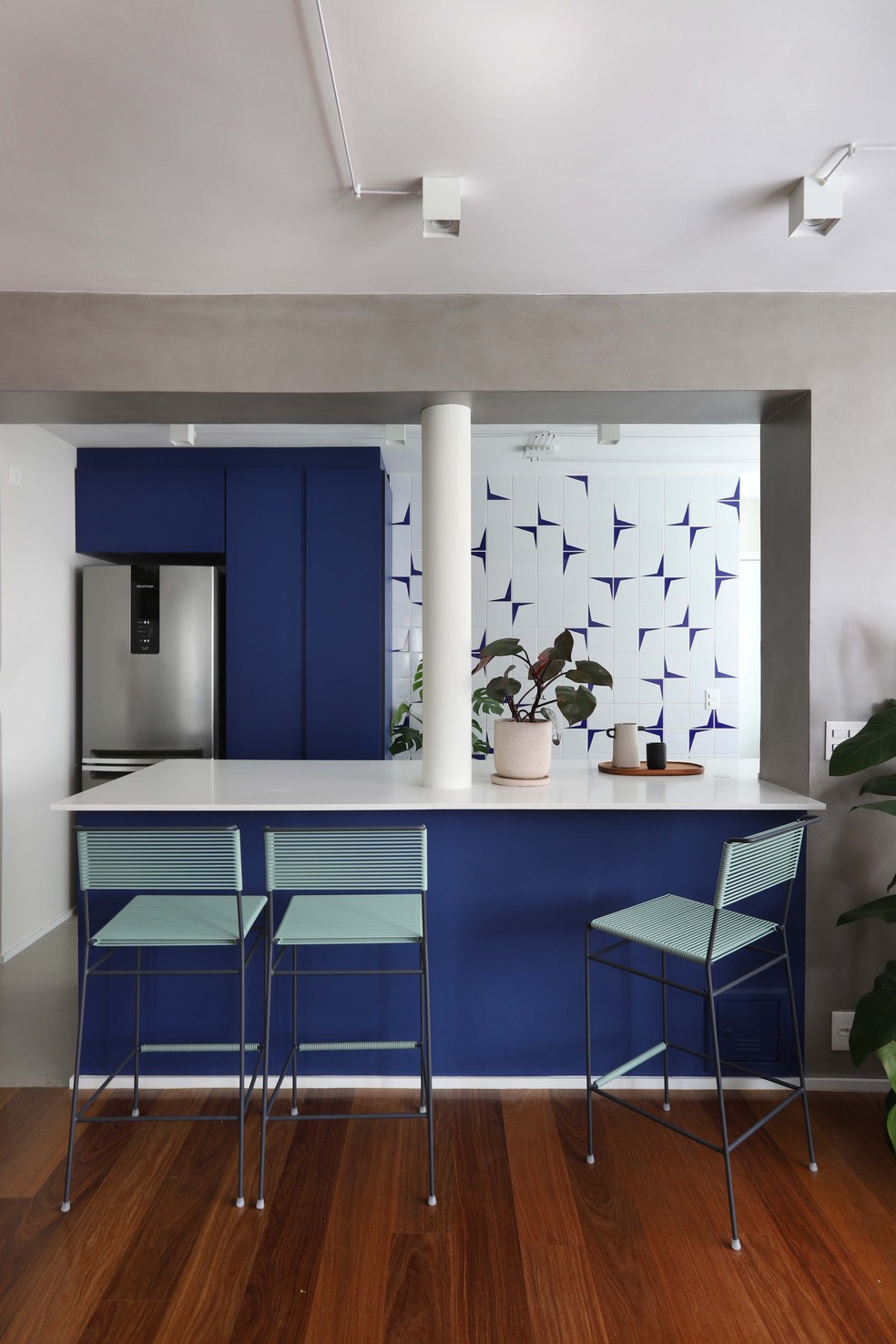 Um tom de azul delimita a cozinha, que exibe o painel de azulejos decorativos — Foto: Mariana Orsi