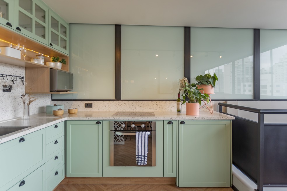 Cozinha com armários verde menta, com puxadores pretos e granilite colorido, projetado pela arquiteta Daniele Capo — Foto: Divulgação